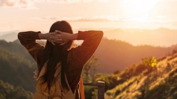 Woman looking at a sunset in the distance Woman looking at a sunset in the distance